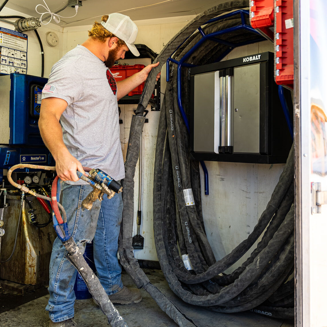 509_Spray_Foam_080 Worker handling hoses in a utility truck