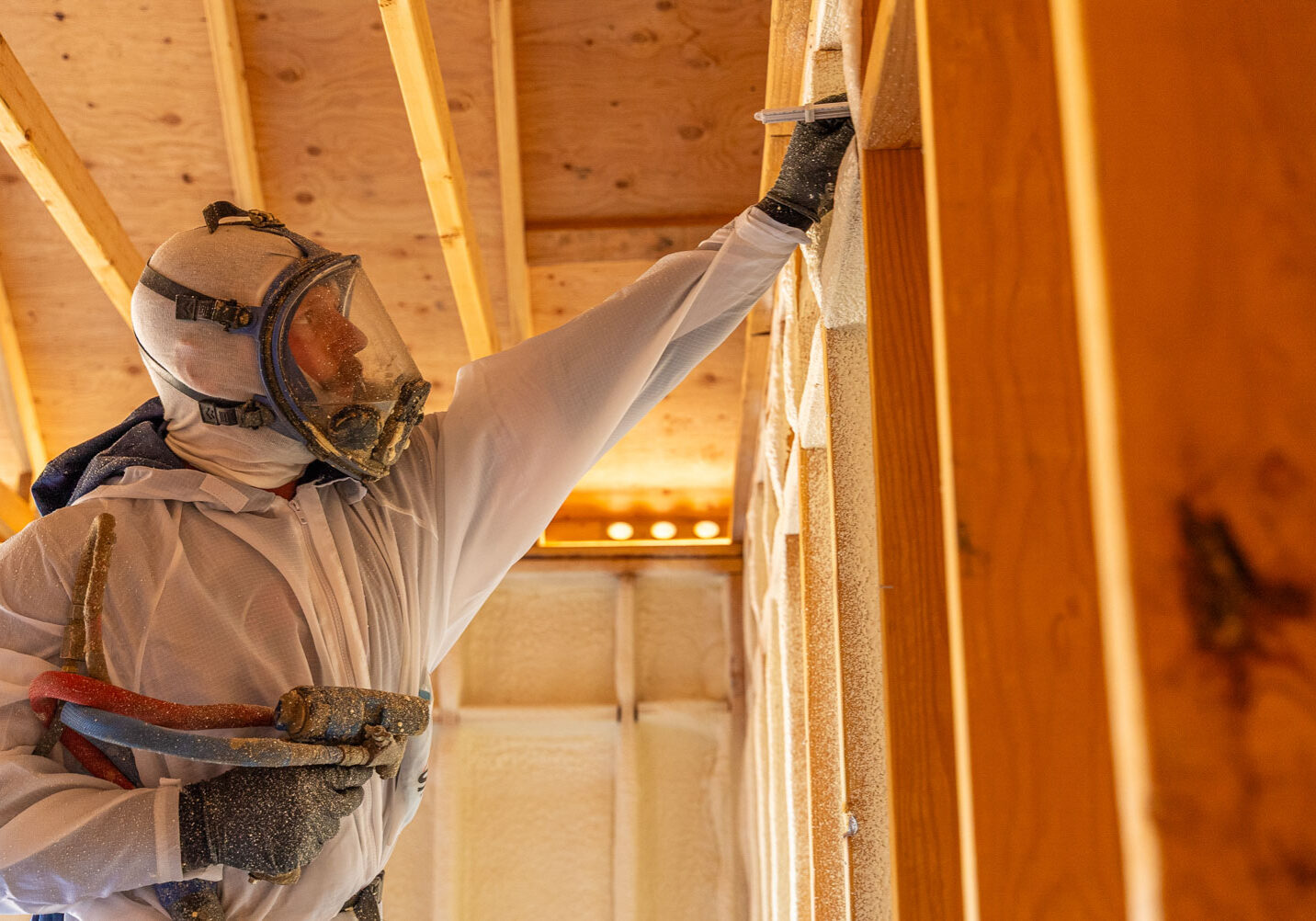 509_Spray_Foam_insulation_033 Worker in protective gear applying spray foam insulation.