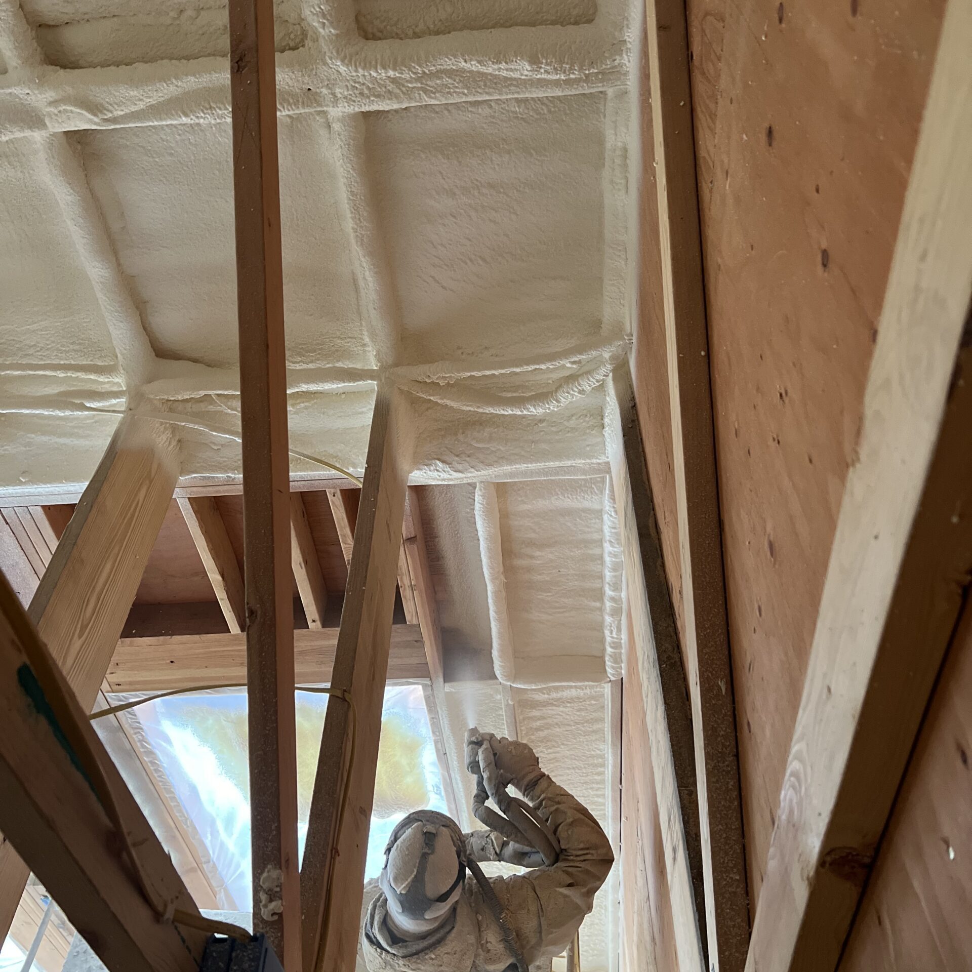IMG_7242 Worker applying spray foam insulation in attic.